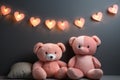 Two cute plush pink teddy bears on a gray background with a garland in the shape of hearts