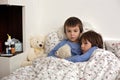 Two cute sick children, boys, staying in bed with fever Royalty Free Stock Photo