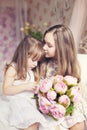 Two cute sisters with bouquet of peonies tenderly hugging at provence interior background