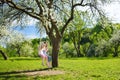 Two cute sisters having fun on a swing in blossoming old apple tree garden outdoors on sunny spring day. Royalty Free Stock Photo