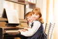 Two cute small girls in uniforms playing piano Royalty Free Stock Photo