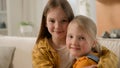 Two cute smiling caucasian kids little girls children sisters friends hugging embracing cuddle embrace hug at home on Royalty Free Stock Photo