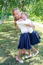 Two cute smilling little girls posing in front of their school.