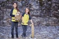 Two cute teenage females with skateboard and plushy toy.