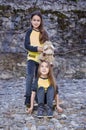 Two cute teenage females with skateboard and plushy toy.