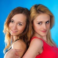 Two cute teenage girls on blue background