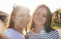Two cute teenage girls smile and pose for camera. Lovely teen female friends in casual clothes make selfies outdoors Royalty Free Stock Photo