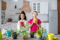 Two cute teens standing with flower pots in their hands