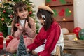 Two cute young Asian girls are playing in the living room on a Christmas holiday together