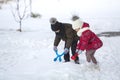 Two cute young children in warm clothing with bright snow clips playing having fun making snowballs on winter cold day on white br Royalty Free Stock Photo