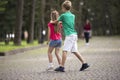 Two cute young laughing children, girl and boy, brother and sister having fun on blurred bright sunny summer park alley green Royalty Free Stock Photo