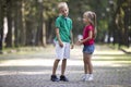 Two cute young laughing children, girl and boy, brother and sister having fun on blurred bright sunny summer park alley green Royalty Free Stock Photo