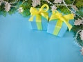 Two cyan gift boxes tied with yellow ribbon on an aqua background. Royalty Free Stock Photo