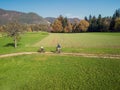 Two cyclists enjoying a ride along the road across pastures in an autumn Royalty Free Stock Photo