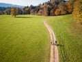 Two cyclists enjoying a ride along the road across pastures in an autumn Royalty Free Stock Photo