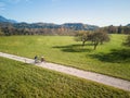 Two cyclists enjoying a ride along the road across pastures in an autumn Royalty Free Stock Photo