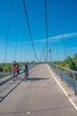 Two cyclists riding bicycles through modern footbridge over Elbe river near to Magdeburg, Germany, early Autumn Royalty Free Stock Photo