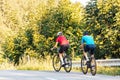 Two cyclists riding uphill the asphalt forest road Royalty Free Stock Photo