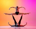 Two dancers, stylish sportive couple, male and female models dancing contemporary dance on colorful gradient yellow pink Royalty Free Stock Photo