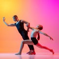 Two dancers, stylish sportive couple, male and female models dancing contemporary dance on colorful gradient yellow pink Royalty Free Stock Photo