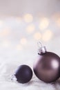 Two dark Christmas balls on white lace on light and warm bokeh b Royalty Free Stock Photo