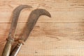 Two dated and used billhooks on wooden background Royalty Free Stock Photo