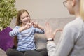 Two deaf girls talking gestures on sofa Royalty Free Stock Photo