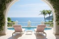 Two deck chairs on terrace with pool with stunning sea view. Traditional mediterranean white architecture with arch. Summer Royalty Free Stock Photo