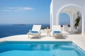 Two deck chairs on terrace with pool with stunning sea view. Traditional mediterranean white architecture with arch. Summer Royalty Free Stock Photo