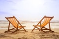 Two deckchairs on the beach at sunset with a tropical sea background Royalty Free Stock Photo
