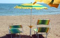 two deckchairs and an umbrella of a resort in front of the sea Royalty Free Stock Photo