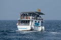 Two decks boat full of tourists during whale watching tour far in the ocean
