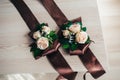 Two Decoration buttonhole bracelet on hand with brown ribbons. made of roses, decorative plants. beautiful tender wedding bouquet Royalty Free Stock Photo