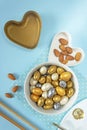 Two decorative forms in the form of hearts with almonds in yellow, silver, gold and white glaze