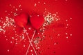 Two decorative hearts on a stick with ribbon. Bright background with silver sequins and round confetti Royalty Free Stock Photo