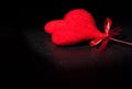 Two decorative velvet red hearts on black dark light and on wood table, concept of valentine day Royalty Free Stock Photo