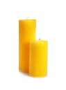 Two decorative yellow wax candles on white background Royalty Free Stock Photo