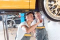 Two dedicated auto mechanics tuning a car through the modificati