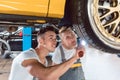 Two dedicated auto mechanics tuning a car through the modification of the rims Royalty Free Stock Photo