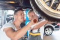 Two dedicated auto mechanics tuning a car Royalty Free Stock Photo