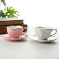 Elegant pink and white ceramic teacups with saucers and books Royalty Free Stock Photo