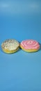 two delicious donuts with different flavors, on a blue paper background Royalty Free Stock Photo