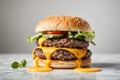 Two delicious homemade burgers of beef, cheese and vegetables on an old wooden table. Fat unhealthy food close-up.