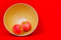 Pair of new zealand red apples in a bamboo pot against red background