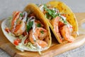 Two delicious shrimp tacos on a wooden board in closeup, colorful mexican food photo