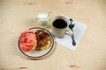 Two delicious sugared ring donuts served on white plate with a cup of hot drink