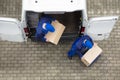 Two Delivery Men Unloading Cardboard Box From Truck Royalty Free Stock Photo