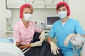 Two dentists in masks sit in dental clinic