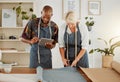 Two designers using a digital tablet while working with material at work. Young african american tailor talking and Royalty Free Stock Photo