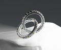 Two diamond platinum rings floating on a white fabric background.